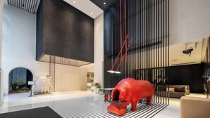Un interior moderno con una gran escultura roja, un suelo a rayas negras y blancas y un diseño minimalista.