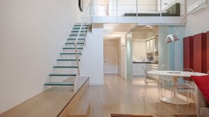 Um interior moderno com uma escada, área de refeições e cozinha.