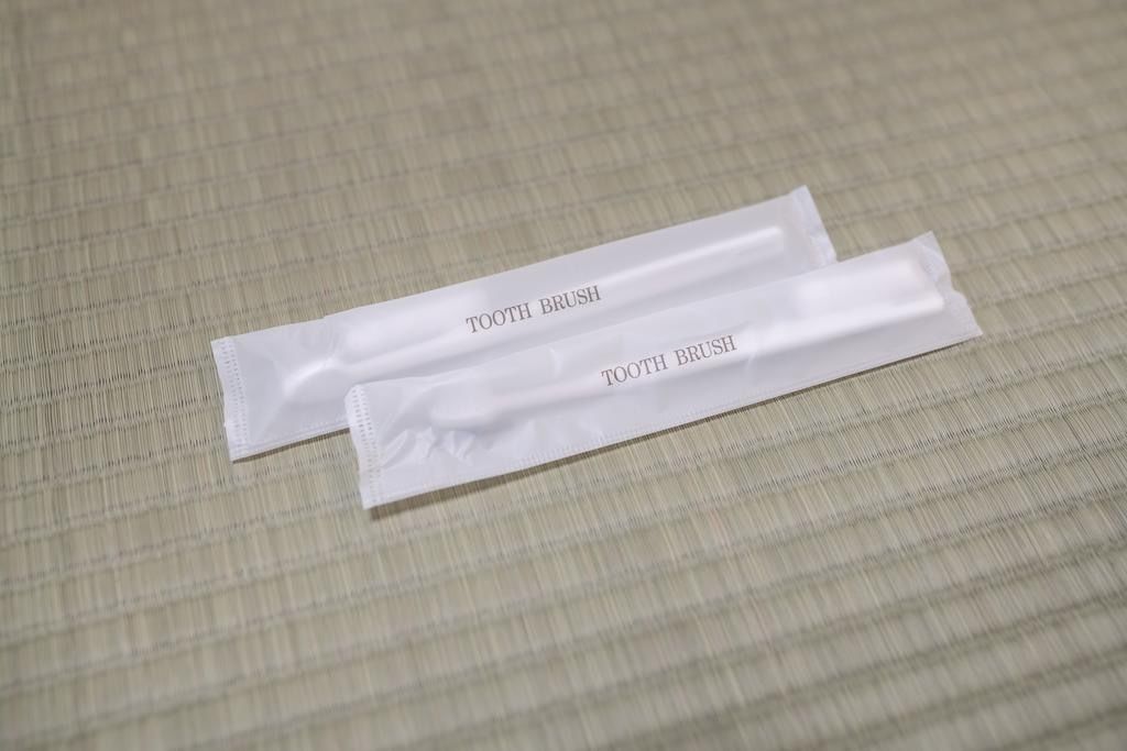 Due confezioni di spazzolino da denti bianche su una superficie strutturata.
