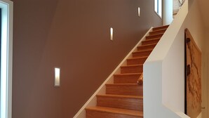 A wooden staircase with white walls and recessed lighting. - "LAZY DAYZ" Currarong beach home.   50m from unspoilt beaches and walking tracks (Currarong)