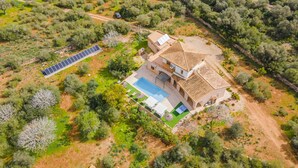 Ein Luftbild eines Hauses mit Swimmingpool, Solaranlage und Garten.