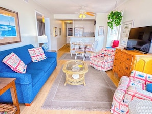 A living room with a blue sofa, a coffee table, and a television.