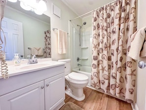 A bathroom with a shower, toilet, and sink.