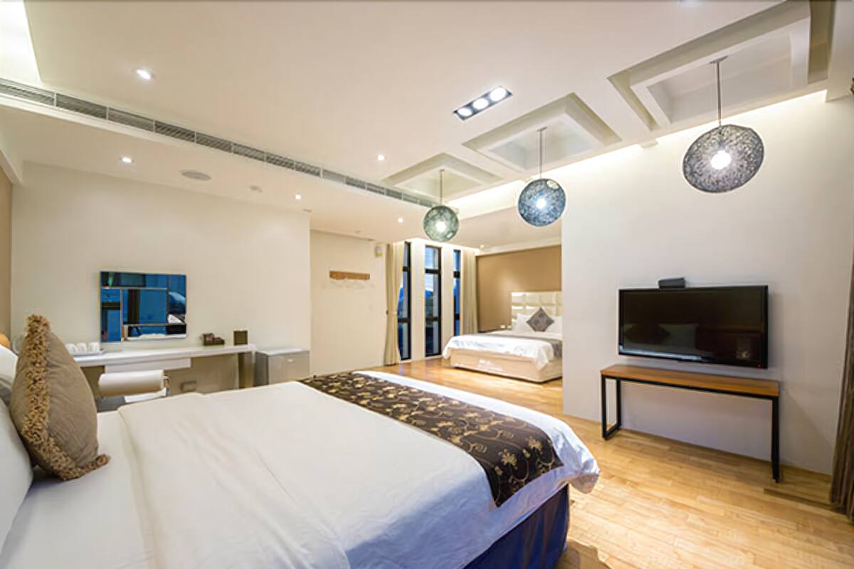 Un dormitorio moderno con una cama grande, un televisor y una zona de escritorio.