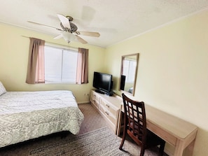 A bedroom with a bed, a desk, a chair, a television, and a ceiling fan. - Tilghman Beach and Racquet Club 222 (North Myrtle Beach)
