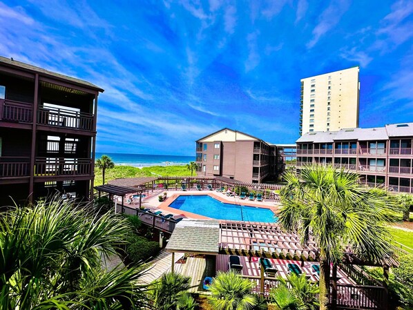 Relax by the central pool surrounded by lounge areas and enjoy stunning beach views from your balcony.