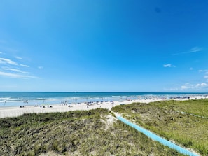 Relax on the beach with comfortable seating and umbrellas, steps from the ocean.