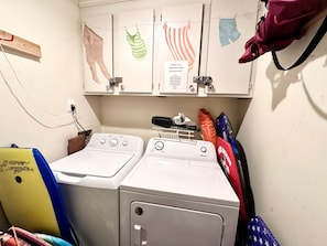 A laundry area with two washing machines, a drying rack, and a sign instructing to clean the dryer lint filter. - Tilghman Beach and Racquet Club 222 (North Myrtle Beach)