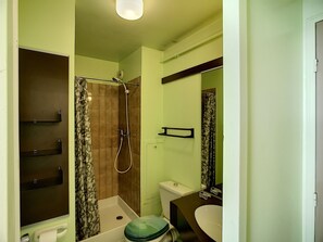 A bathroom with a shower, toilet, and sink.