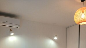 A neatly made bed with a tufted headboard, two bedside tables with lamps, and a hanging light fixture. - F2 ON THE GROUND FLOOR 150m from the beaches and shops / 5pers / 48m2 (Cagnes-Sur-Mer)