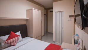 A hotel room with a bed, a wardrobe, a bathroom with a shower, and a TV mounted on the wall. - Hotel O Balcon Biru (Jakarta)
