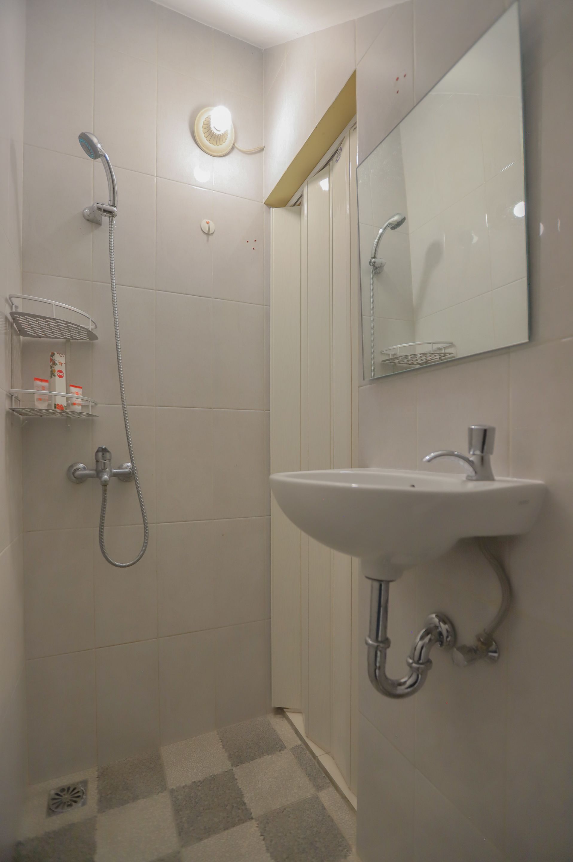 Un baño con ducha, lavamanos y espejo.