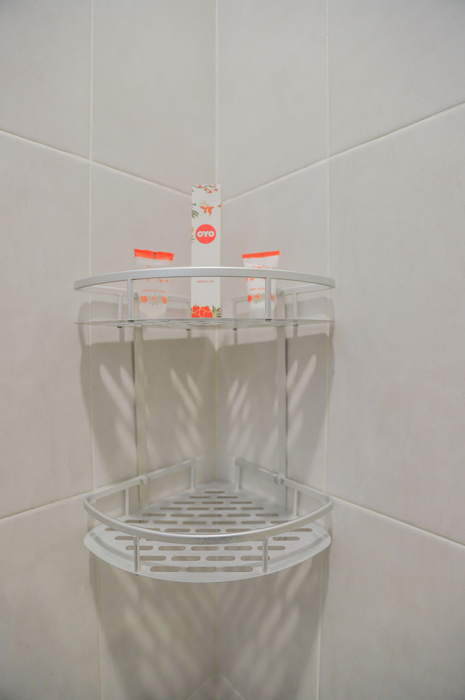 Ein Badezimmer mit weiß gefliesten Wänden und einem weißen, runden, mehrstufigen Spender.