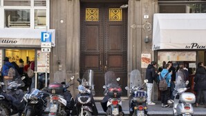 A street scene with parked motorcycles, a building with a double door, and a sign indicating a parking area. - The apartment is located in the historic center just three minutes from the fountain of Neptune and a short walk from all the most important artistic and culinary destinations of the city.In this neighborhood you can breathe a ville lumière atmosphere (Bologna)