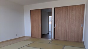 A room with tatami flooring and sliding wooden doors. - Machi no Hotel (Fujiyoshida)