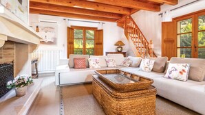 A cozy living room with a wooden ceiling, a fireplace, a sofa set, and a staircase. - VILLA CIRCE - Exclusive villa with indoor heated pool in Fornalutx. (fornalutx)