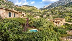 A hillside village with stone buildings, a swimming pool, and lush greenery. - VILLA CIRCE - Exclusive villa with indoor heated pool in Fornalutx. (fornalutx)
