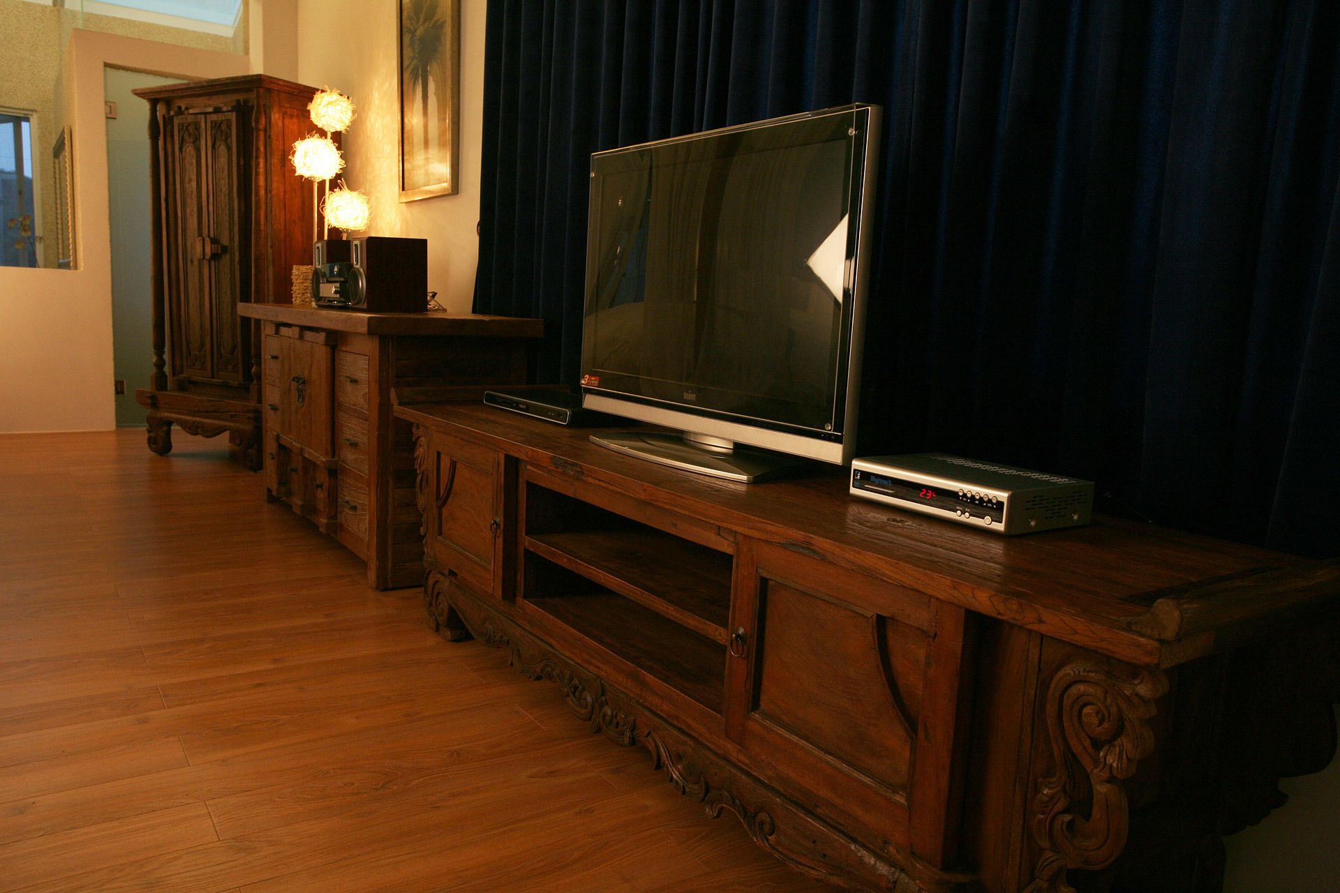 A wooden entertainment center with a flat-screen TV and a DVD player.