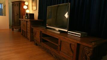 A wooden entertainment center with a flat-screen TV and a DVD player.
