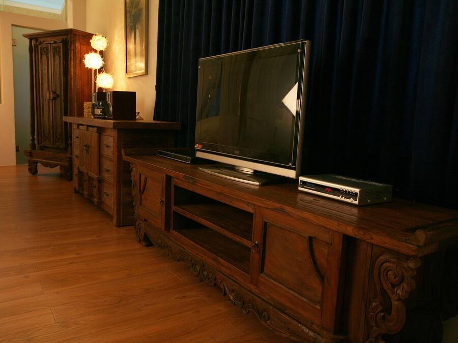A wooden entertainment center with a flat-screen TV and a DVD player.