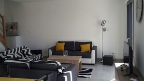 A modern living room with a sofa, a coffee table, and a TV.