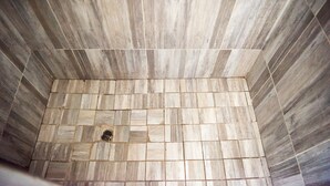 Un área de ducha con azulejos y desagüe central.