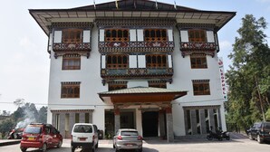 Um edifício de vários andares com elementos arquitetônicos tradicionais, incluindo varandas elaboradas e uma entrada imponente.