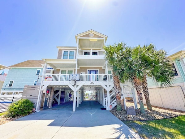 A two-story house with a balcony, a garage, and a clear sky.