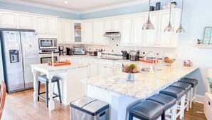 A modern kitchen with white cabinets, stainless steel appliances, and a granite countertop. - Luxury 4Bedroom/ 4 Bath with Private Salt-Water Pool! (North Myrtle Beach)