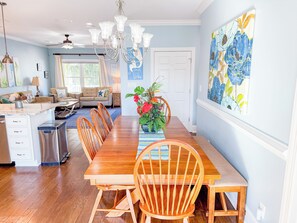 A dining area with a wooden table, chairs, and a chandelier.