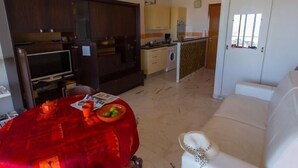 A compact living space with a dining area, kitchenette, and a sofa. - Seafront studio with terrace, near beaches and center, Free Wifi (Menton)