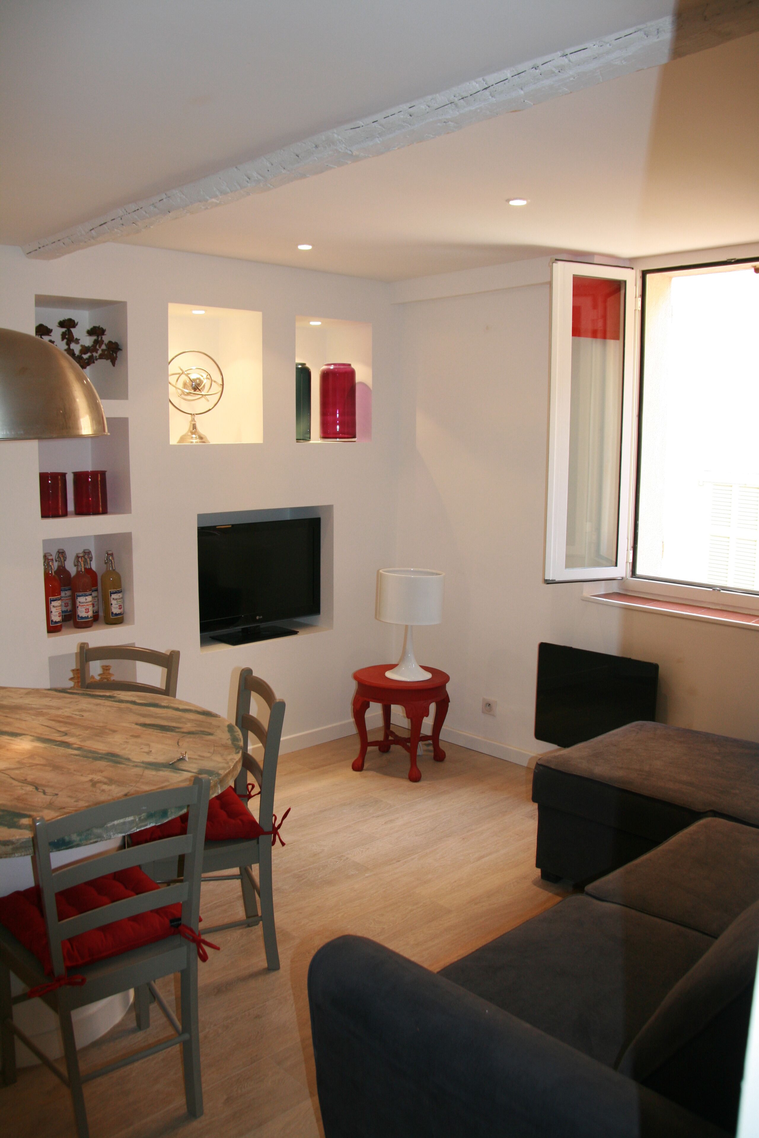 Una sala de estar con televisión, una mesa de comedor y un sofá.