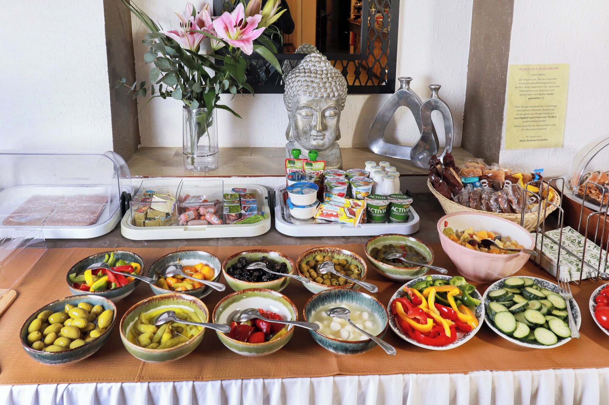 A buffet table with various food items and condiments.