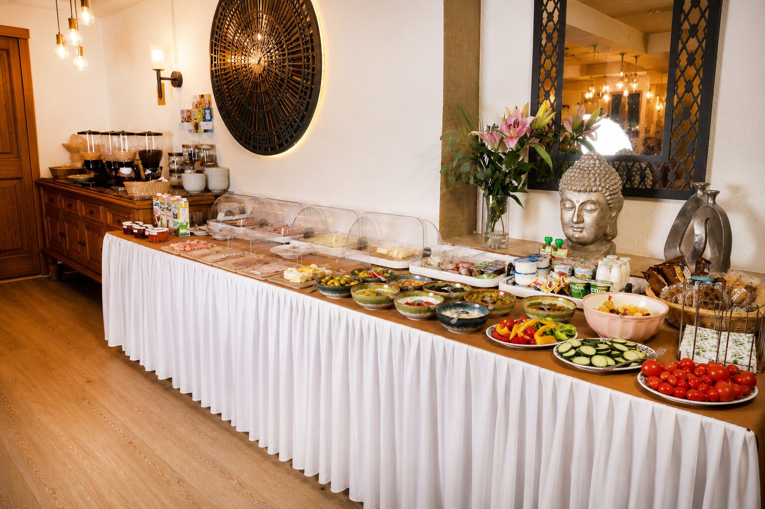 Ein Buffet mit verschiedenen Speisen und einer Buddha-Statue.