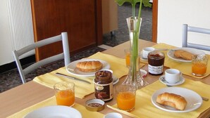 A breakfast table set with croissants, orange juice, and condiments. - Residence La Carruba (Diano Marina)