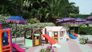 A children's play area with slides, a small house, and colorful play structures. - Residence La Carruba (Diano Marina)
