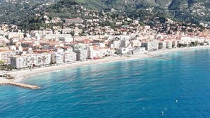 Un paysage urbain côtier avec une plage et des montagnes en arrière-plan.
