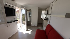 Une cuisine moderne avec des meubles blancs, un four encastré et une fenêtre.