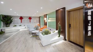 Eine moderne Hotelhalle mit Empfangstresen, Sitzgelegenheiten und einer Kakteenausstellung.