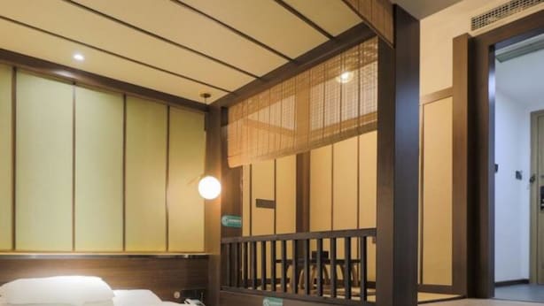Ein Hotelzimmer mit einem Bett, einer Holzvertäfelung und einer kleinen Sitzecke.