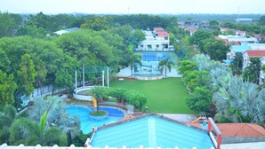 Zona residencial con piscina, canchas de tenis y abundante vegetación.