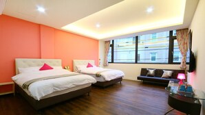 A hotel room with two beds, a sofa, a glass table, and a window with curtains. - Chi Yu 85 (Ji'an)