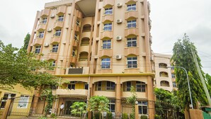 A multi-story hotel with balconies and air conditioning units. - Abla Apartment (Dar es Salaam)