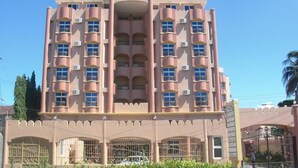 A pink multi-story building with balconies, labeled "ABLA HOTEL APARTMENTS". - Abla Apartment (Dar es Salaam)