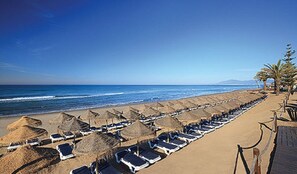 Na praia, espreguiçadeiras, toalhas de praia 