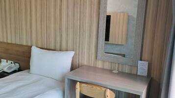 A hotel room with a bed, a desk, and a chair.