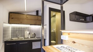 A modern kitchen with a sink, kettle, and a mirror. - Atomic Apartment 02 (Belgrade)