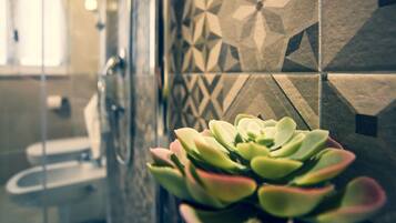 A bathroom with a geometric tile backsplash and a potted succulent plant.
