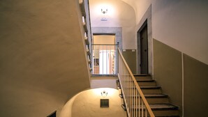 A staircase with a wooden handrail and a light fixture above it. - Kapsott B&B (Bisceglie)
