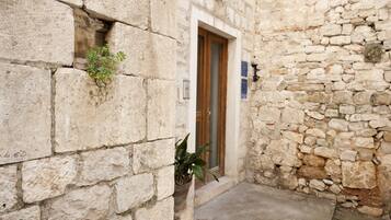 A stone building with a wooden door and a small window.